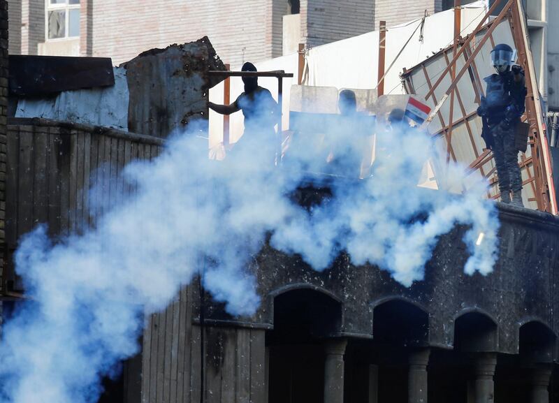 Members of Iraqi security forces use tear gas during ongoing anti-government protests in Baghdad. Reuters