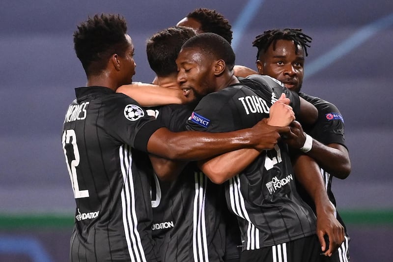 Lyon's French forward Moussa Dembele celebrates with teammates after scoring his first goal, Lyon's second one, during the UEFA Champions League quarter-final football match between Manchester City and Lyon at the Jose Alvalade stadium in Lisbon on August 15, 2020. / AFP / POOL / FRANCK FIFE
