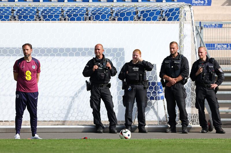 England's manager Gareth Southgate watches a training session as police personnel stand guard in Jena, eastern Germany. AFP