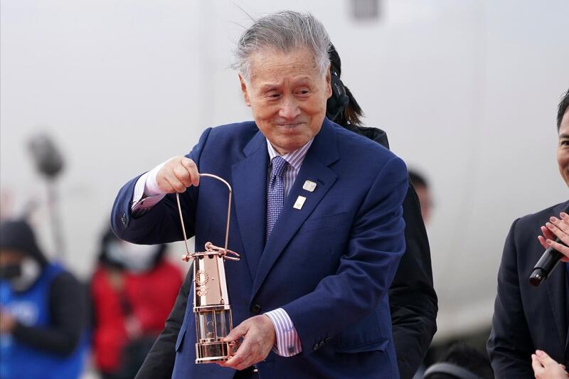 FILE - In this March 20, 2020, file photo, Tokyo 2020 Olympics chief Yoshiro Mori carries the Olympic flame during the Flame Arrival Ceremony at Japan Air Self-Defense Force Matsushima Base in Higashimatsushima in Miyagi Prefecture, north of Tokyo. Mori resigned Friday, Feb. 12, 2021 as the president of the Tokyo Olympic organizing committee following sexist comments implying women talk too much. (AP Photo/Eugene Hoshiko, File)