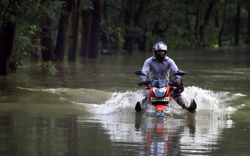 A Sri Lankan motorcyclist rides along a flooded street at Biyagama, just outside the capital Colombo. Ishara S Kodikara / AFP