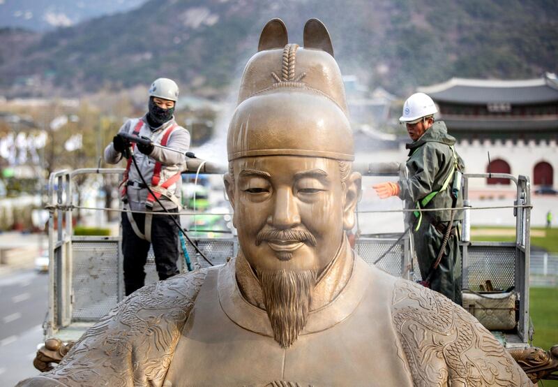 Workers clean the statue of King Sejong at Gwanghwamun Square in central Seoul, South Korea. EPA