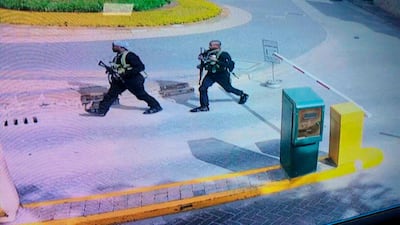 In this grab taken from security camera footage released to the local media, heavily armed attackers walk in the compound of a hotel, in Nairobi, Kenya, Tuesday, Jan. 15, 2019. Extremists launched an attack on a luxury hotel in Kenya's capital, sending people fleeing in panic as explosions and heavy gunfire reverberate through the neighborhood. A police officer says he saw bodies, "but there was no time to count the dead." Al-Shabab _ the Somalia-based extremist group _ is claiming responsibility. (Security Camera Footage via AP)