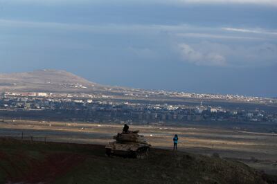 Israeli tourists stand atop a tank abandoned during the October 1973 war in the annexed Golan Heights last year. EPA