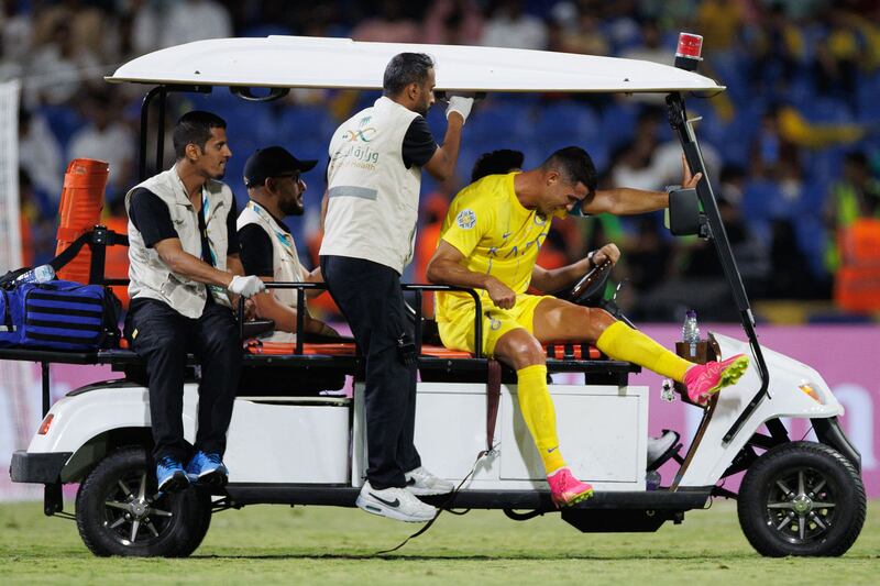 Cristiano Ronaldo is taken off the pitch on buggy after his injury. AFP