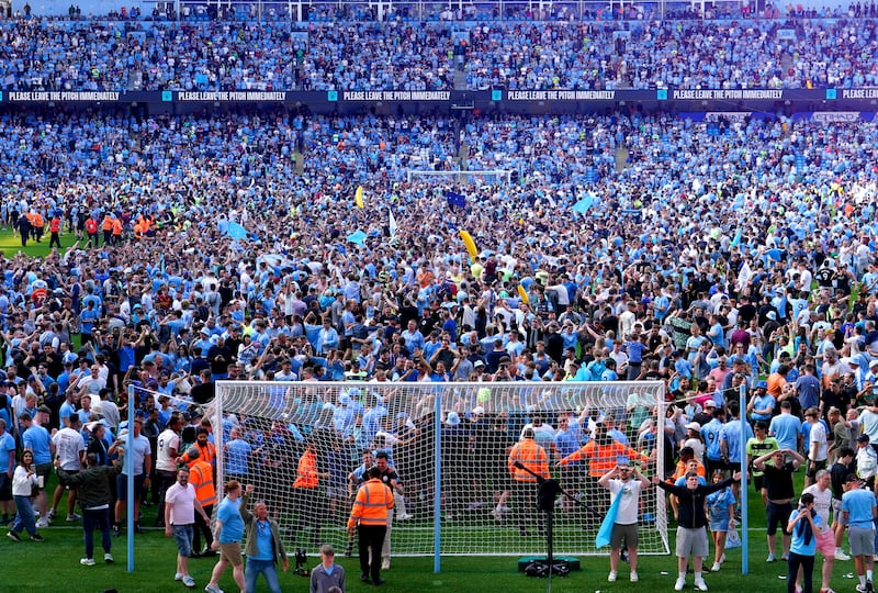 Manchester City fans on the pitch after the match. PA