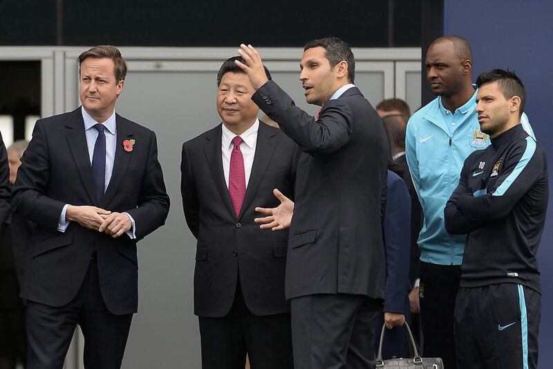 Britain's prime minister David Cameron, left, stands with China's president Xi Jinping, centre, and Manchester City chairman Khaldoon Al Mubarak, third right, during a visit to the City Football Academy in Manchester in October. Joe Giddens / Reuters