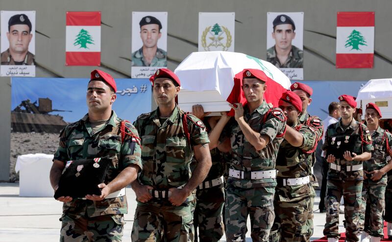 Lebanese army soldiers carry the coffins of 10 of their fallen comrades, who had been taken hostage in 2014 by the Islamic State (IS) group, after their remains were found along the Syrian border during an official funerary ceremony at the Ministry of Defence in Yarze, on the eastern outskirts of Beirut, on September 8, 2017. / AFP PHOTO / ANWAR AMRO
