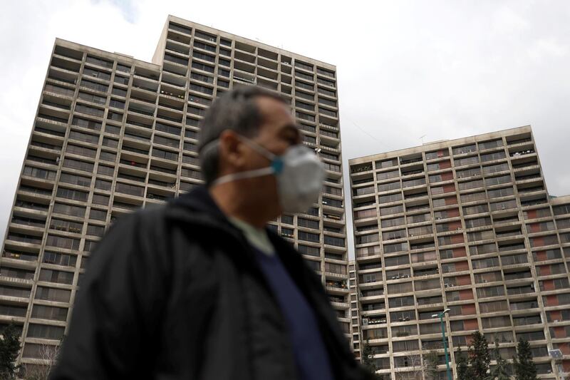 A man walks next to buildings where people stay home in Tehran, Iran on March 26, 2020. WANA / Reuters