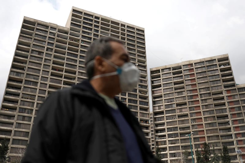 A man walks next to buildings where people stay home in Tehran, Iran on March 26, 2020. WANA / Reuters