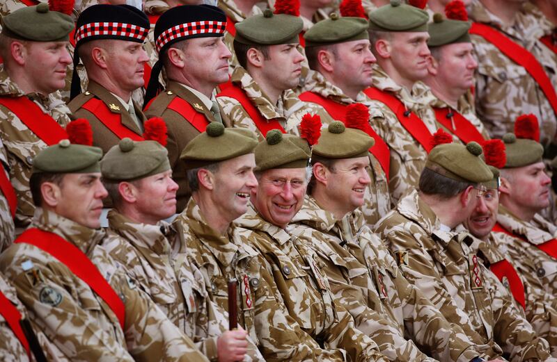 Prince Charles sits for a group picture after presenting campaign medals to soldiers from the Black Watch in Fort George, Scotland, in 2010