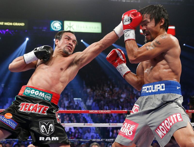 Juan Manuel Marquez, from Mexico, left, lands a left against Manny Pacquiao, from the Philippines, during their WBO world welterweight  fight Saturday, Dec. 8, 2012, in Las Vegas. Marquez won the fight by a knockout. (AP Photo/Eric Jamison) *** Local Caption ***  Pacquiao Marquez Boxing.JPEG-0dbe5.jpg
