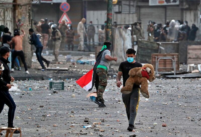 A protester holds his teddy bear during clashes between Iraqi security forces and anti-government demonstrators, at Khilani Square in Baghdad, Iraq. AP Photo