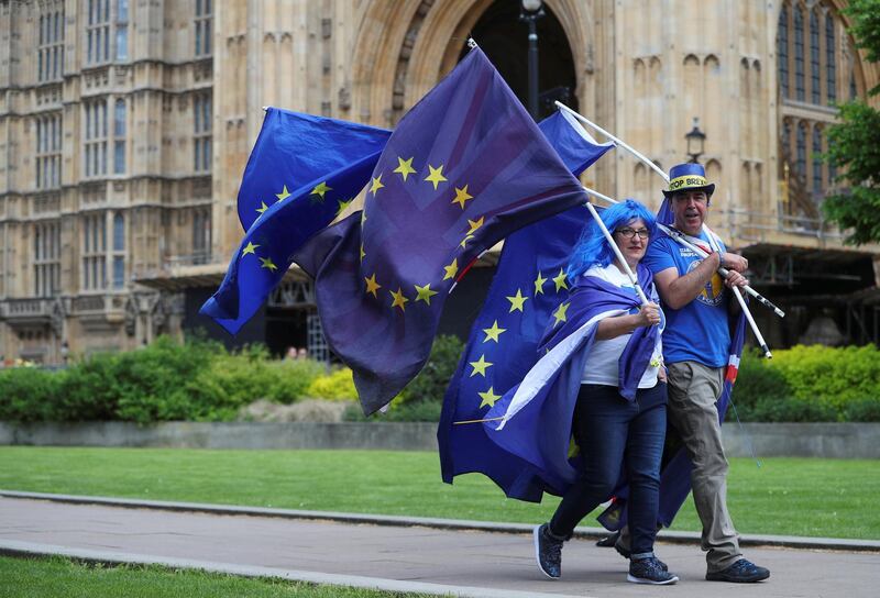 Two anti-Brexit protesters carry flags opposite the Houses of Parliament in London, Britain, May 10, 2018. REUTERS/Hannah McKay