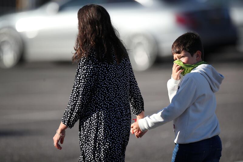 A woman and a child walk during a daily excercise outside the Radisson Blu Hotel. Reuters