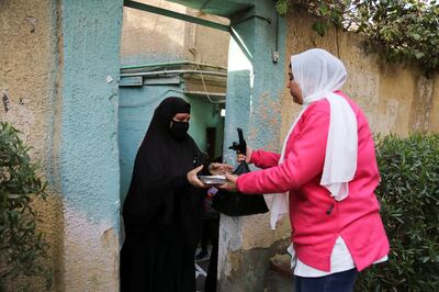 A volunteer handing over a free meal to a family in Helwan, a suburb of the Egyptian capital Cairo. Reuters
