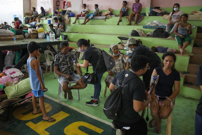 Volunteers provide free medical examinations inside an evacuation center in Santo Tomas, Batangas, Philippines.  EPA