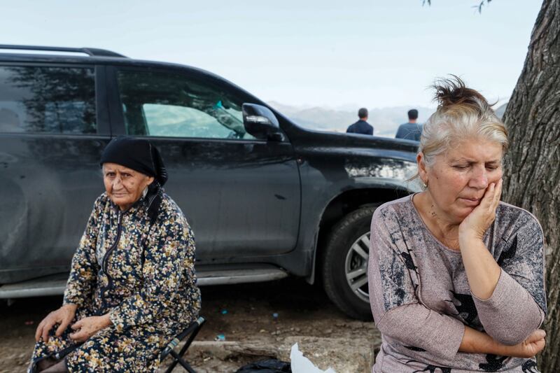 Ethnic Armenians fleeing Nagorno-Karabakh region rest on a roadside after crossing the border with Azerbaijan, near the village of Kornidzor. EPA