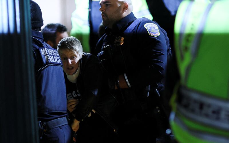 Police detain a demonstrator blocking the entrance to the Democratic National Headquarters in Washington. Reuters