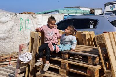Displaced children sit on wooden pallets in a tent camp near the border with Egypt in Rafah. Reuters