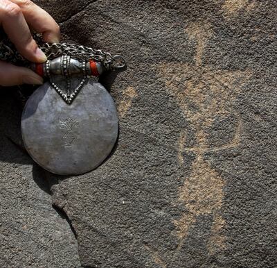 Fujariah City - May 20, 2010 - Archaeologist Michele Ziolkowski holds a medallion with the shape of this petroglyph engraved in it in Wadi Al Hayl near Fujariah City, May 20, 2010. (Photo by Jeff Topping/The National)