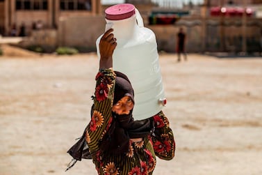 A displaced Syrian brings water back to their camp  in Syria's northeastern city of Hasakah last month. AFP