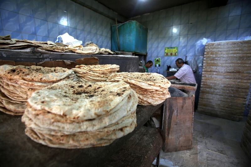 Workers prepare bread at the bakery to be sold for residents at the town of Dhiban. Some poor people have no enough cash to get their daily bread at the bakery and are only able to pay when they get their salaries at the end of the month. (Salah Malkawi for The National)