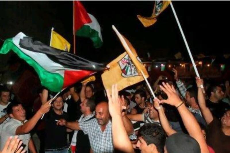 Palestinian Fatah supporters wave Fatah and national flags as they celebrate after voting in elections in Bethlehem.