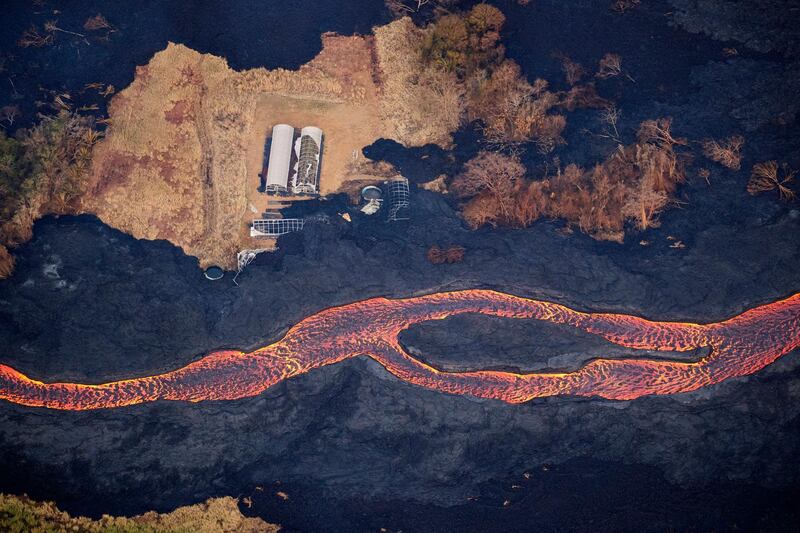 Lava flows past the remains of a greenhouse as it makes its way to the ocean after erupting from a fissure at Kilauea's lower east rift zone in Pahoa, Hawaii. Bruce Omori / EPA