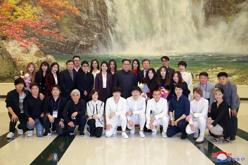 epa06641310 A picture made released by the North Korean Central News Agency (KCNA), the state news agency of North Korea, shows Respected Supreme Leader Kim Jong-un (C), together with his wife Ri Sol Ju, posing for a group photograph with artists after enjoying the performance 'Spring Comes', given by an art troupe from South Korea, at the East Pyongyang Grand Theatre in Pyongyang, North Korea, 01 April 2018 (issued 02 April 2018).  EPA/KCNA