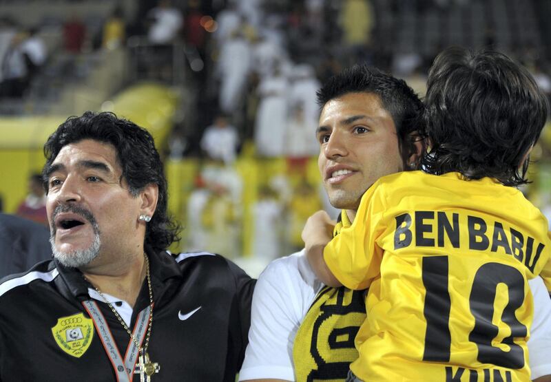 Al-Wasl club's Argentinian head coach Diego Maradona (L) stands with his son in law, Manchester City's Sergio Aguero (C), and his grandson Benjamin at the end of a Gulf Cooperation Council Champions League football match between Al-Wasl and Al-Wehda clubs in Dubai on May 15, 2012. AFP PHOTO/STR (Photo by - / AFP)