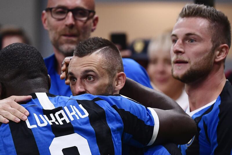 Inter Milan's Croatian defender Marcelo Brozovic celebrates with Inter Milan's Belgian forward Romelu Lukaku after his deflected free kick saw Inter take the lead against AC Milan at San Siro. Inter went on to win the match 2-0. AFP