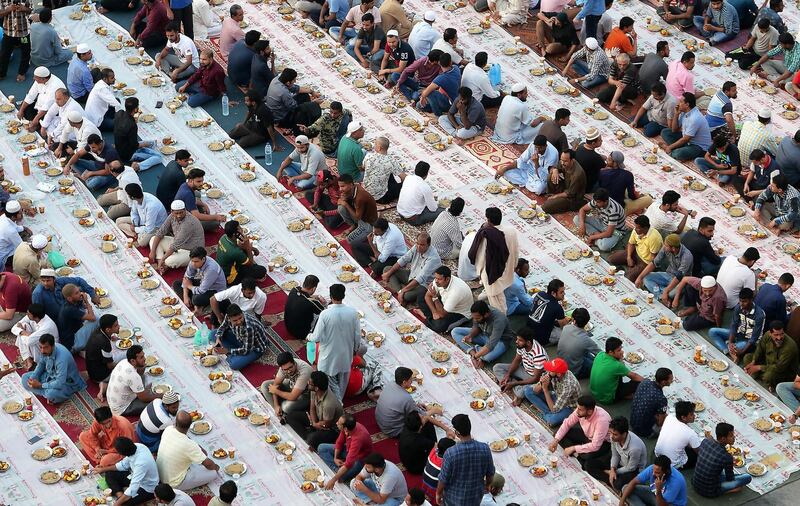 DUBAI,  UNITED ARAB EMIRATES , May 8 – 2019 :-  People sitting together to break their fast during the Ramadan in the parking area near the Al Ghubaiba bus station in Bur Dubai in Dubai. Every year this kind of free Iftar organised by local shop owners and businessmen near the Al Ghubaiba bus station in Dubai. As a photographer I have covered my first Iftar at the same area in 2007. ( Pawan Singh / The National ) For News/Standalone/Big Picture/Online/Instagram