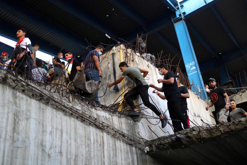 Iraqi demonstrators climb inside the high-rise Turkish Restaurant Building. Reuters