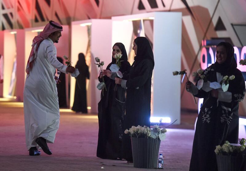 Saudi women distribute flowers to incoming attendees. Fayez Nureldine / AFP