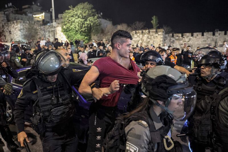 Israeli policemen detain a Palestinian man. AFP