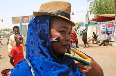 A Sudanese protester with the national flag of Sudan painted on her face, flashes the victory sign during a sit-in outside the army headquarters in the capital Khartoum on May 1, 2019.  The UAE said today it supported an "orderly" transition in Sudan where military leaders who toppled veteran president Omar al-Bashir are locked in a standoff with protesters demanding civilian rule. / AFP / ASHRAF SHAZLY
