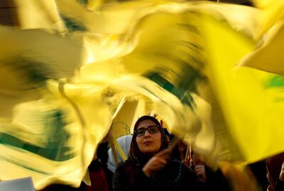 A Hezbollah supporter waves her group flags during an election campaign speech by Hezbollah leader Sayyed Hassan Nasrallah, in a southern suburb of Beirut, Lebanon, Friday, April 13, 2018. Nasrallah says Monday's attack on the T4 air base ushers in a new phase that puts Israel in a state of "direct confrontation" with the Islamic Republic of Iran. (AP Photo/Hussein Malla)