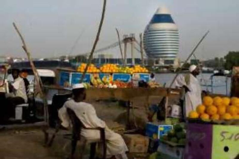 A market selling fruits and vegetables outside of the ferry launch along the Nile River in Khartoum contrasts with the luxury five-star hotel built by Libyan investors (egg shaped in background) along the banks of the river. While much of Sudan is experiencing an economic boom, and investors mainly from the Gulf countries and China, are flocking to Africa's largest country, the majority of the population remains poor.  *** Local Caption ***  IMG_6885.jpg