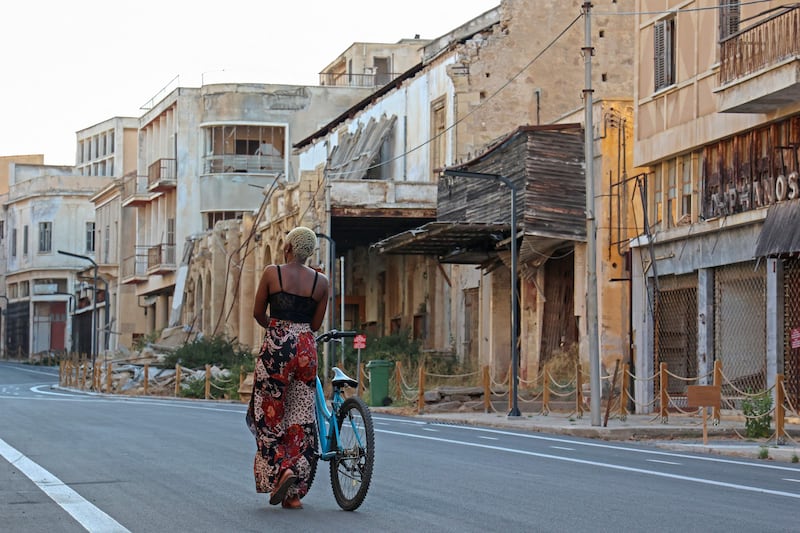 A visitor wheels her bicycle as she tours Varosha. Once favoured by celebrities, Varosha had been a ghost town since 1974 when its Greek-Cypriot residents fled as Turkish troops advanced.