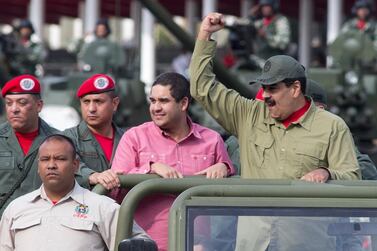 Nicolas Maduro gestures as he reviews a military parade with his son, second right, in Caracas, Venezuela on April 13, 2018. AP Photo