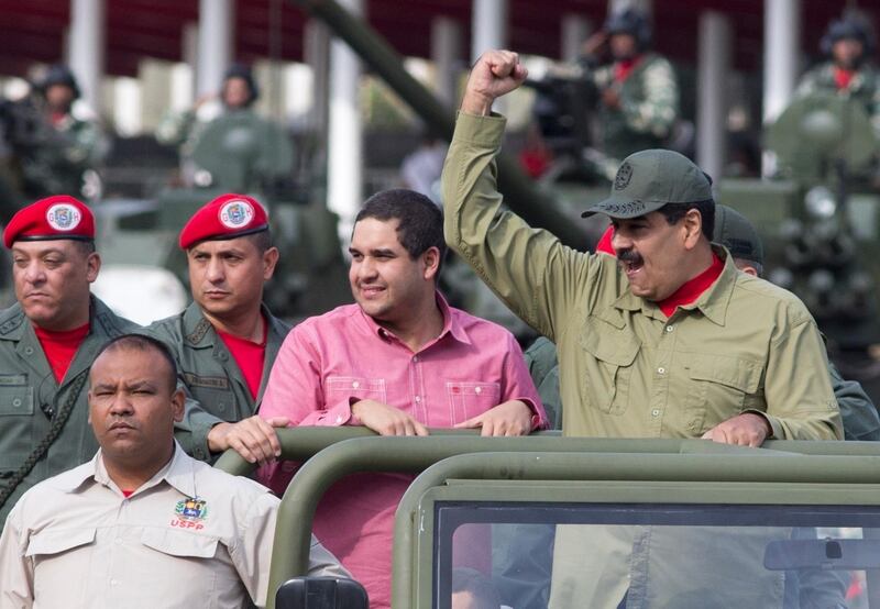 FILE - In this April 13, 2018 file photo, Nicolas Maduro Jr., center, accompanies his father, Venezuela's President Nicolas Maduro in a military parade, in Caracas, Venezuela. An action by the U.S. Treasury Department on Friday, June 28, 2019, freezes any U.S. assets belonging to Nicolas Maduro Jr. and prohibits American from doing business with him. (AP Photo/Ariana Cubillos, File)