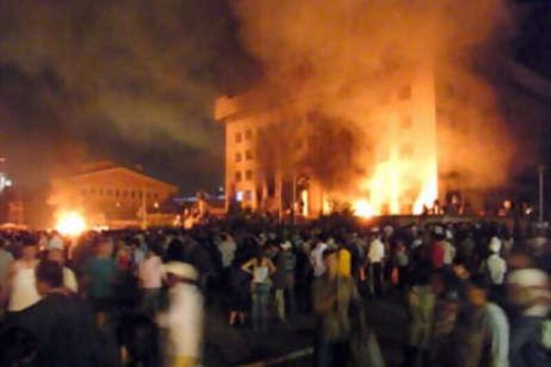 Protesters from the rival Democratic Party gather outside the headquarters of the former communist Mongolian People's Revolutionary Party, which was set alight and looted, during a violent protest in Ulan Bator on July 1, 2008.