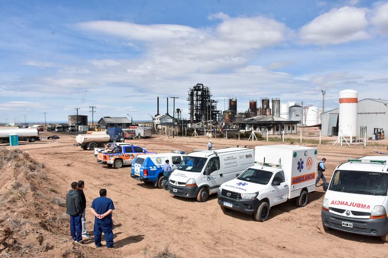 Medical responders stand outside the New American Oil refinery in southern Argentina. Reuters