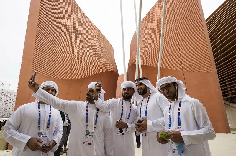 Young volunteers from the UAE pose for selfies and capture the historic moment in Milan outside their national pavilion on day one of the long-awaited Milan Expo 2015. Giuseppe Aresu / AP Photo