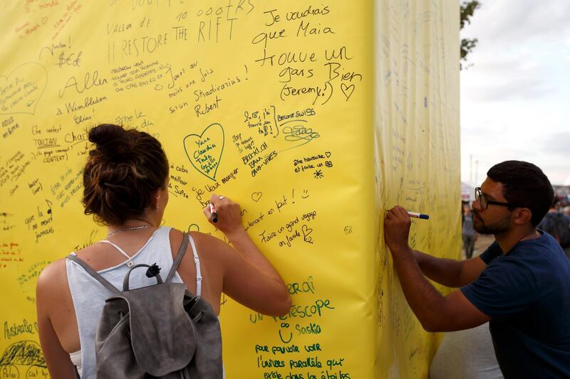 Festival goers write their wishes on a giant lantern at the Murten Festival of Lights booth, during the 43th edition of the Paleo Festival, in Nyon, Switzerland.  EPA / SALVATORE DI NOLFI