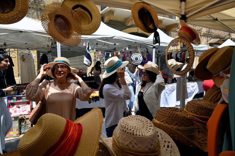 Visitors try on sun hats at a stand during the Gemmayze Street Festival, in Lebanon's capital Beirut. All photos: EPA 