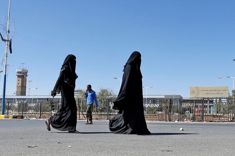 Women walk by the almost deserted airport. AFP