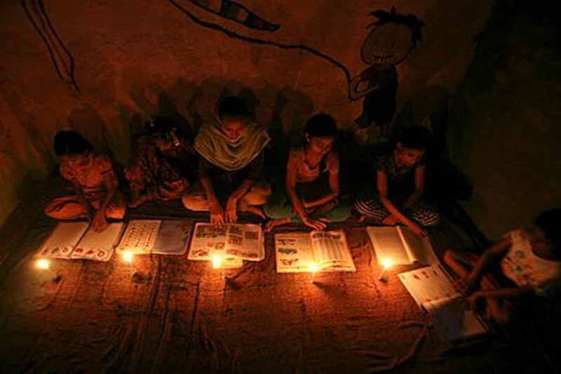Muslim girls study in the light of candles inside a madrasa or religious school during power-cut in Noida on the outskirts of New Delhi July 30, 2012. Grid failure left more than 300 million people without power in New Delhi and much of northern India for hours on Monday in the worst blackout for more than a decade, highlighting chronic infrastructure woes holding back Asia's third-largest economy. REUTERS/Parivartan Sharma (INDIA - Tags: EDUCATION SOCIETY ENERGY RELIGION)