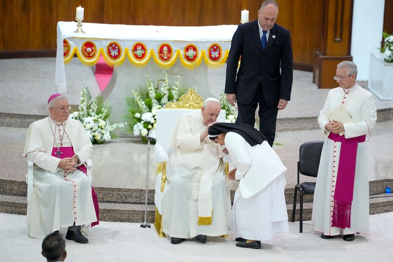 Pope Francis blesses a nun during a prayer meeting at the Manama church. AP